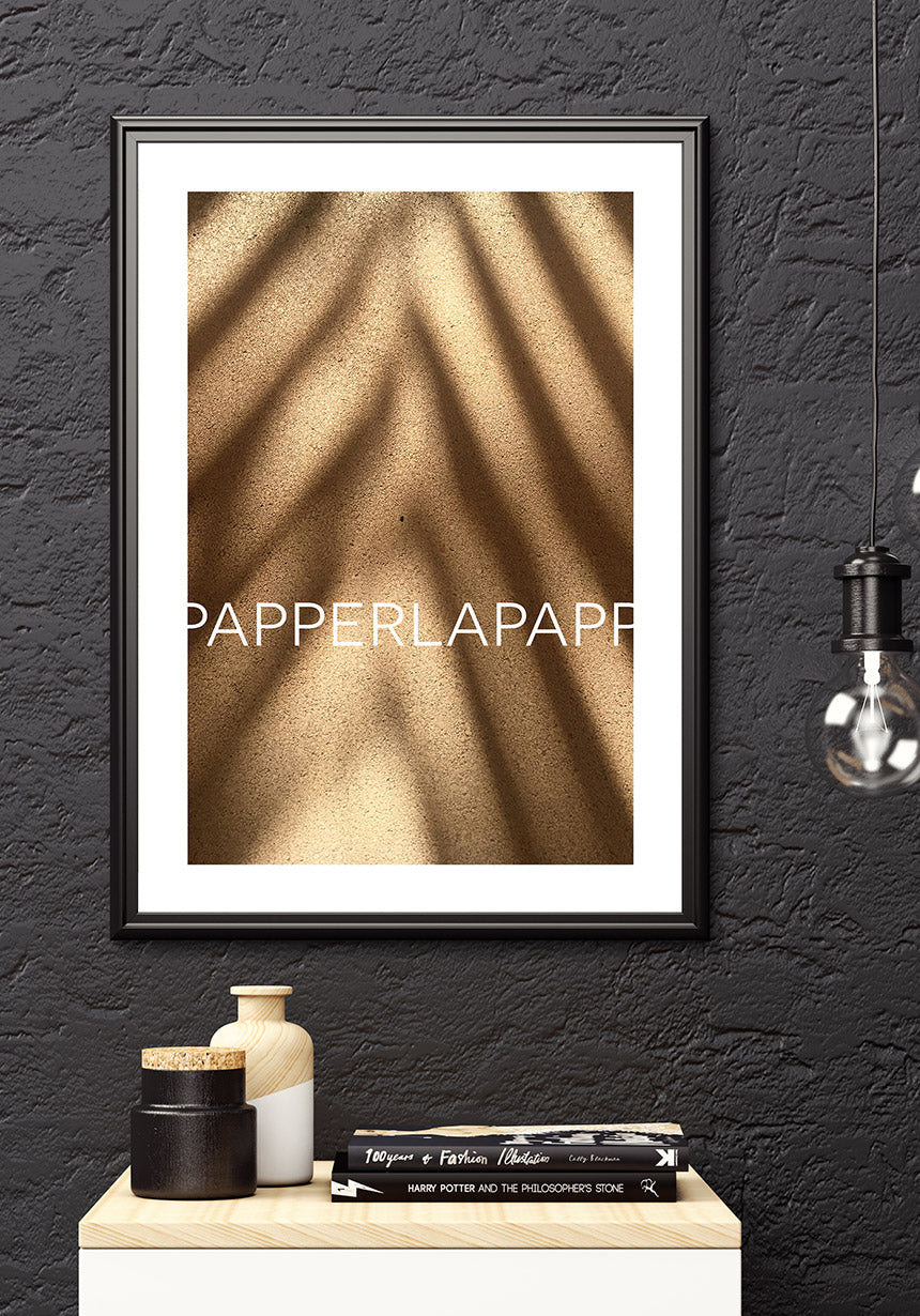 Poster on sand with shadow over sideboard