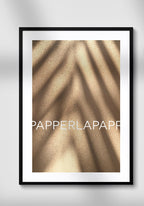 Poster on sand with shade on white wall