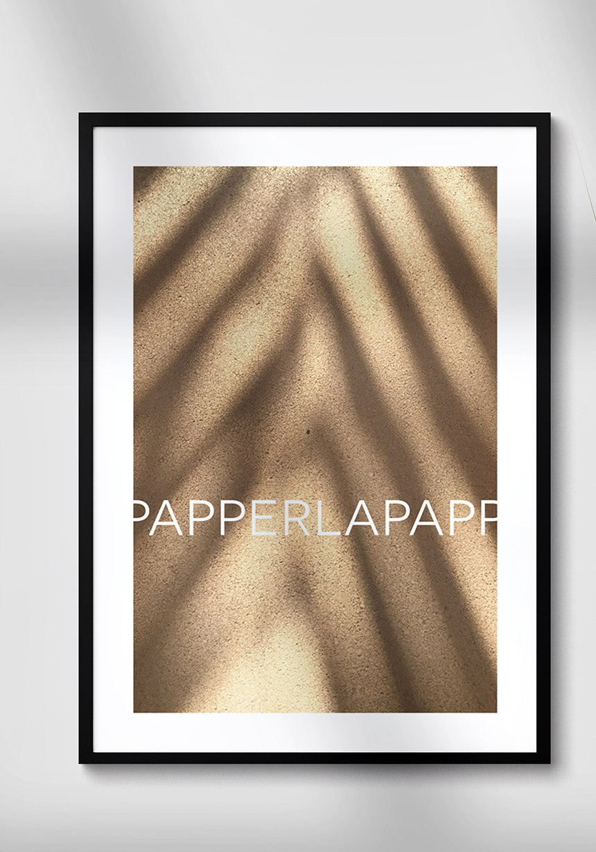 Poster on sand with shade on white wall